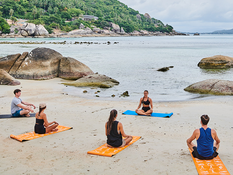 Yoga and stretching on the sand beside the sea